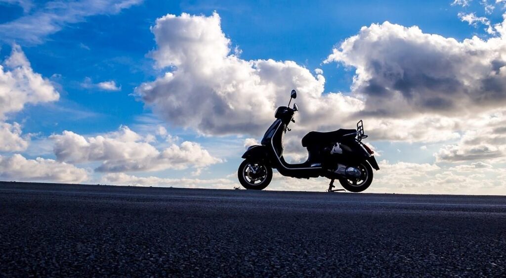 Silhouette of an electric scooter under blue sky – exploring which electric scooter battery is removable.
